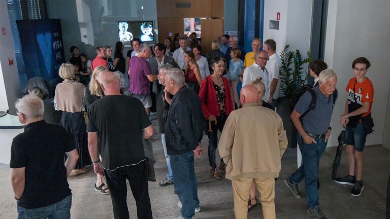 A group of people standing in a room Description automatically generated with medium confidence